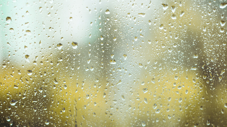 雨の滴が垂れるガラス窓